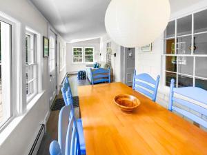 a dining room with a wooden table and blue chairs at 379 Oak Street Harwich Cape Cod - - Harwich Hideaway in Harwich