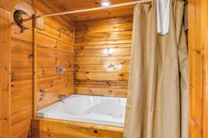 a bath tub in a room with wooden walls at Moonlight Romance in Pigeon Forge +19 photos