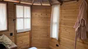 a room with wooden walls and windows in a cabin at Deluxe Taida Chalet in Villa de Leyva