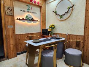 Cette chambre comprend une table, des chaises et un miroir. dans l'établissement Nanxi JiangTingXuanGe Homestay, à Yongjia