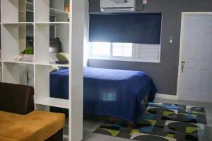 a bedroom with a blue bed and a white door at Carter's Nest in Kingston