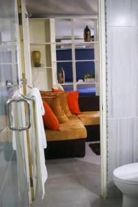 a bathroom with a bed with orange pillows and a toilet at Carter's Nest in Kingston