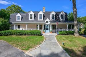 a large white house with a flag at Relax by the Lake: Private Beach Views in Centerville