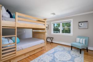 1 dormitorio con 2 literas y 1 silla en 192 Great Marsh Road Centerville Cape Cod - - The Dragonfly, en Centerville