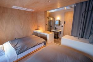 a bedroom with a bed and a sink and a mirror at APARTMENTS by Bed and Craft in Inami