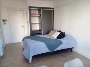 1 dormitorio con 1 cama con sábanas y almohadas azules en Departamento Centro Mar del Plata en Mar del Plata