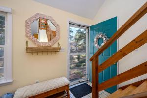 a mirror on a wall next to a stairway at Turtle Dreams: Cozy Cape Cod Bayside Retreat in Eastham