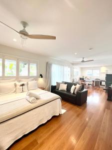 a bedroom with a large bed and a couch at The Beach Shack Byron Bay in Byron Bay