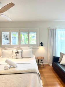 sypialnia z dużym łóżkiem i niebieską kanapą w obiekcie The Beach Shack Byron Bay w mieście Byron Bay