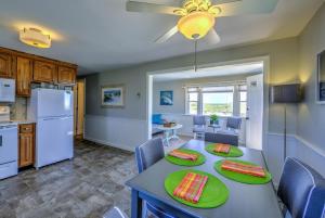 a kitchen and dining room with a table with green plates at 355 B Phillips Road Sagamore Beach - Cape Cod in Sagamore Beach