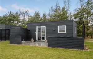 a black tiny house on top of a yard at 2 Bedroom Nice Apartment In Vggerlse in Marielyst