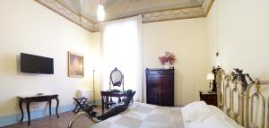 a bedroom with a bed with a mirror and a tv at Historical Suites VVM in Lecce