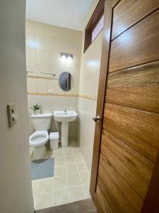 uma casa de banho com um WC e um lavatório em MyGuide Travellers Inn em Coron