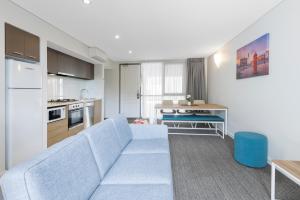 a living room with a blue couch and a kitchen at Quest Portland in Portland