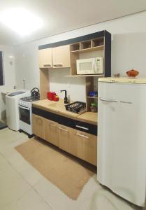 a kitchen with a stove and a refrigerator at Apto em Santo Ângelo in Santo Ângelo