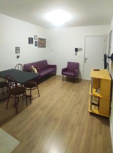 a living room with a couch and a table and chairs at Apto em Santo Ângelo in Santo Ângelo