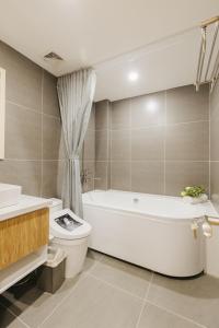 a bathroom with a tub and a toilet and a sink at Myrcella Urban Studio in Hanoi