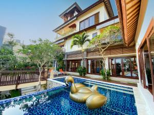 a swimming pool with an elephant pool noodle in front of a building at Alea Villa by Premier Hospitality Asia in Jimbaran