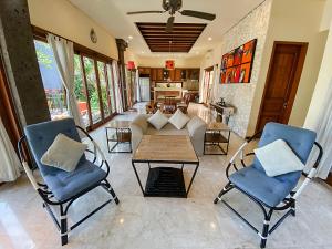 a living room with two chairs and a table at Alea Villa by Premier Hospitality Asia in Jimbaran