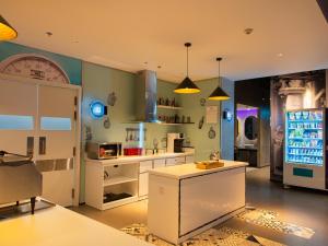 a large kitchen with a refrigerator and a counter at SOJO Hotel Hoa Binh in Hòa Bình