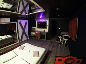 Habitación con cama, escritorio y TV. en Motel Scorpios, en Lages