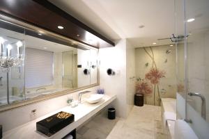 een badkamer met een wastafel, een spiegel en een douche bij InterContinental Dalian, an IHG Hotel in Dalian