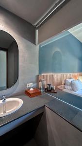 a bathroom with a sink and a mirror and a bed at Umadewi Surf & Retreat in Pulukan