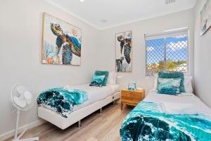 1 dormitorio con 2 camas y ventana en 12 Calming Coral Beach Beautiful 2brm, en Perth