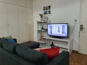 ein Wohnzimmer mit einem Sofa und einem TV in der Unterkunft Monoambiente Centro ESTRATÉGICA UBICACIÓN in Buenos Aires
