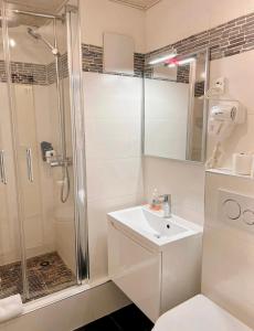 een witte badkamer met een douche en een wastafel bij City Center Apartment in Zürich
