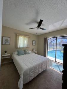 um quarto com uma cama e uma ventoinha de tecto em Sunshine Paradise em Cape Coral