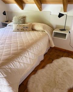 a bedroom with a bed with a white comforter and a rug at La Tante in San Carlos de Bariloche +12 photos
