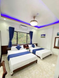 2 camas en una habitación con techos azules en VENUS HOTEL catba, en Cat Ba
