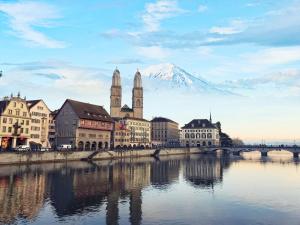 a city with a mountain in the background and a river at City Center Apartment in Zurich