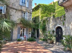 a courtyard of an old stone building with ivy at Studio au cœur du Vieil Antibes in Antibes