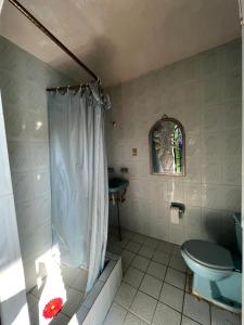 bagno con tenda per la doccia e servizi igienici di La casa club a Oacalco