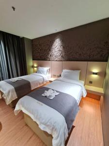 a hotel room with two beds with towels on them at Extreme Boutique Hotel in Kluang