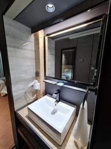 uma casa de banho com um lavatório branco e um espelho. em Extreme Boutique Hotel em Keluang
