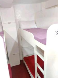 a small room with a bunk bed and cabinets at Dormitels.ph The Fort BGC in Manila
