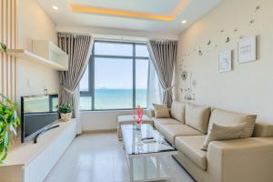 a living room with a couch and a large window at MySea Nha Trang Apartments in Nha Trang