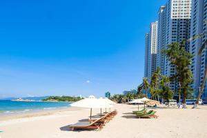 a beach with chairs and umbrellas and the ocean at MySea Nha Trang Apartments in Nha Trang