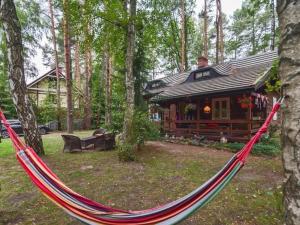 uma rede em frente a um chalé de madeira em Holiday home in an idyllic location in Debki em Dębki