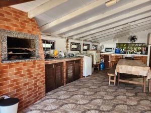 une cuisine avec une table et un mur en briques dans l'établissement Casa Praia da Lagoinha, à Florianópolis