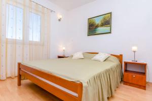 En eller flere senge i et værelse på Apartments Stara Maslina