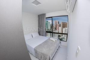sypialnia z łóżkiem i dużym oknem w obiekcie Apartamento Royale na praia de Boa Viagem w mieście Recife