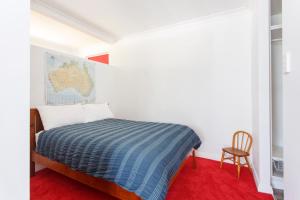 1 dormitorio blanco con 1 cama y 1 silla en Studio 8 - self contained studio near South Fremantle, en Spearwood