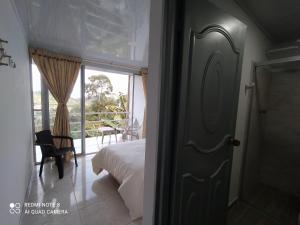 1 dormitorio con 1 cama y puerta a un balcón en Casa turística Santa Helena y el Danubio, en Líbano