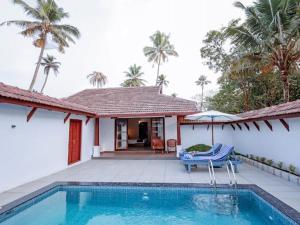 a villa with a swimming pool and a house at Abad Turtle Beach in Mararikulam