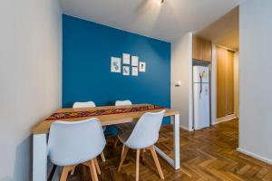 una sala da pranzo con parete blu e tavolo e sedie di Av Colon 158 - B Centro - Full Equipado y Cómodo a Córdoba