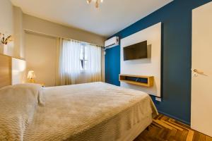 1 dormitorio con 1 cama grande y pared azul en Av Colon 158 - B Centro - Full Equipado y Cómodo en Córdoba